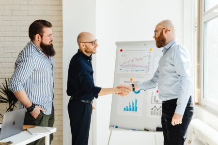 Two professionals shaking hands over a financial agreement representing private credit transactions