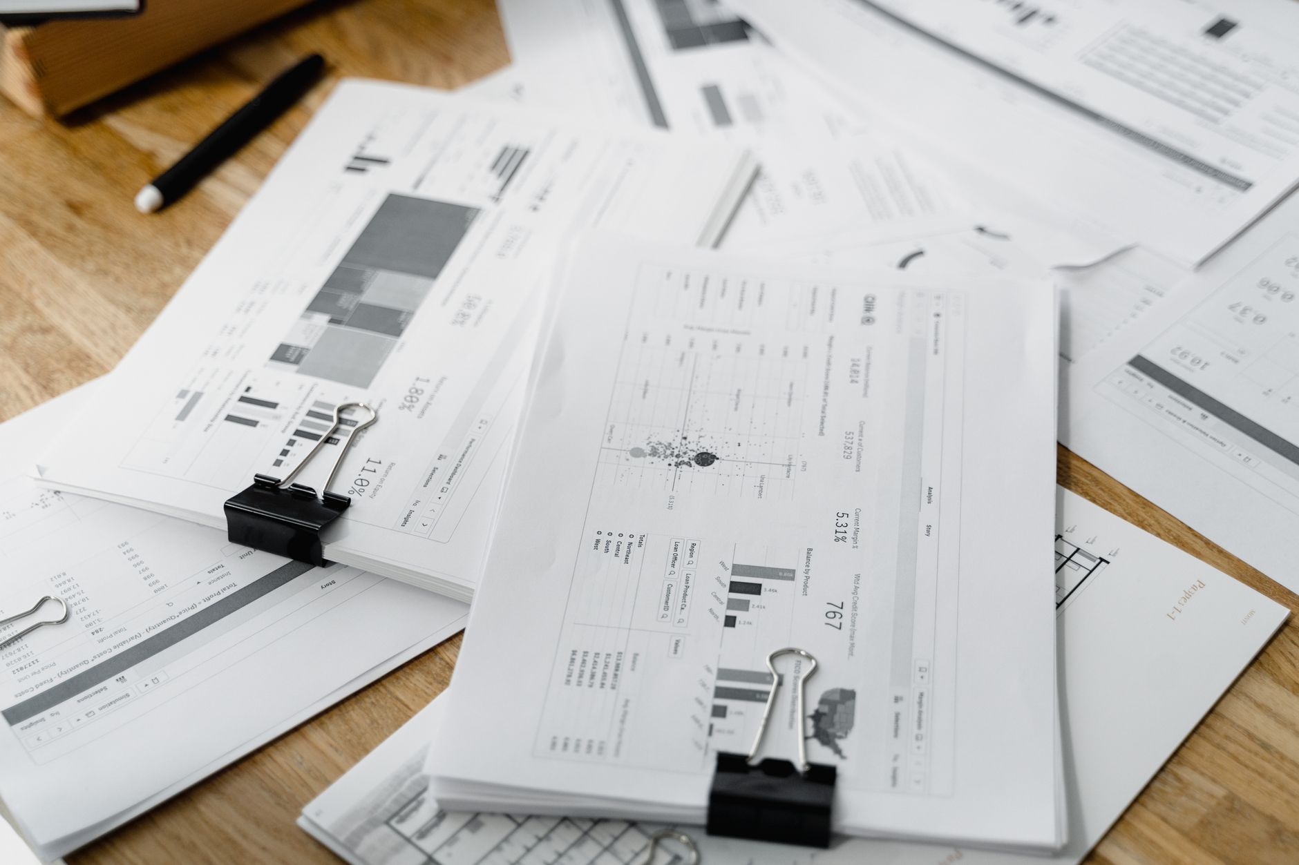 Financial documents and analysis papers spread across a desk representing loan underwriting work