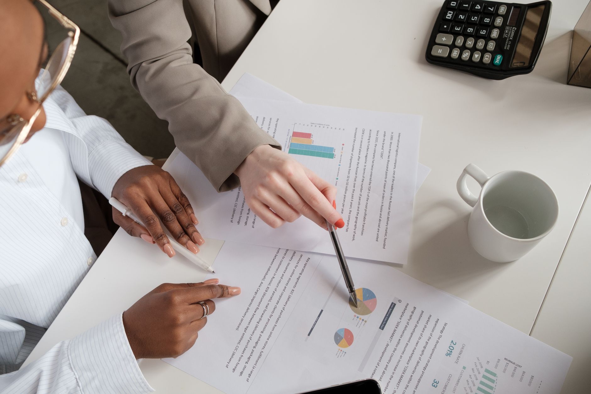 Financial analyst reviewing portfolio risk documents and charts at a desk