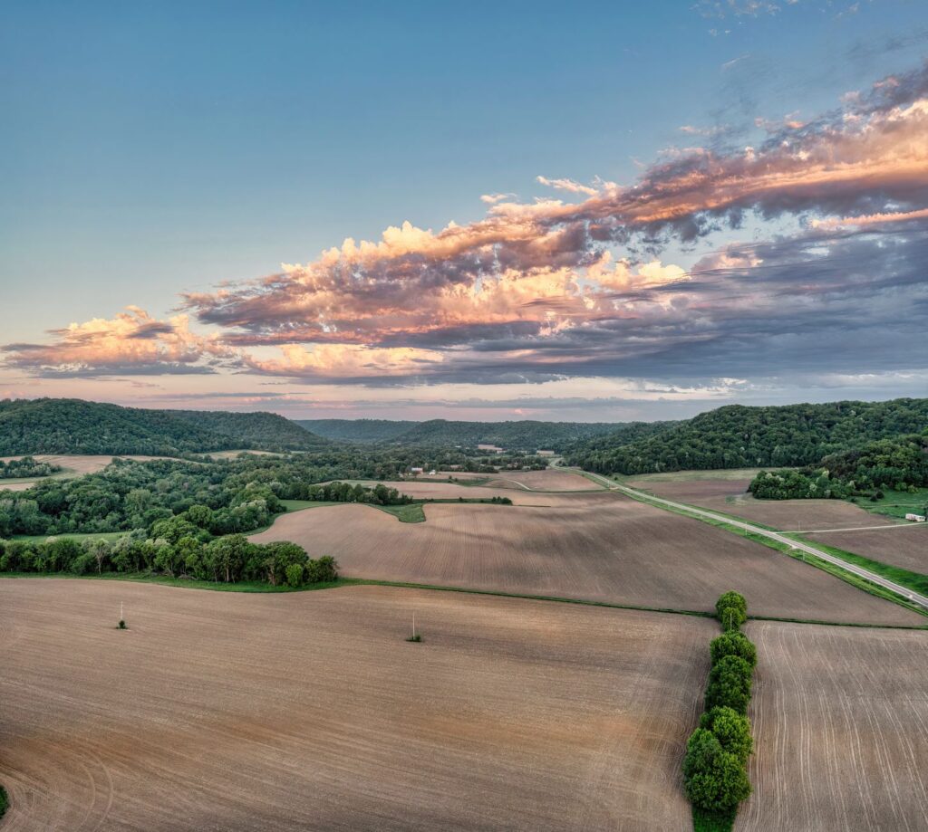Farmland REITs Quietly Attract Inflation-Hedging Institutional Capital Aerial view of rows of crops on flat agricultural farmland