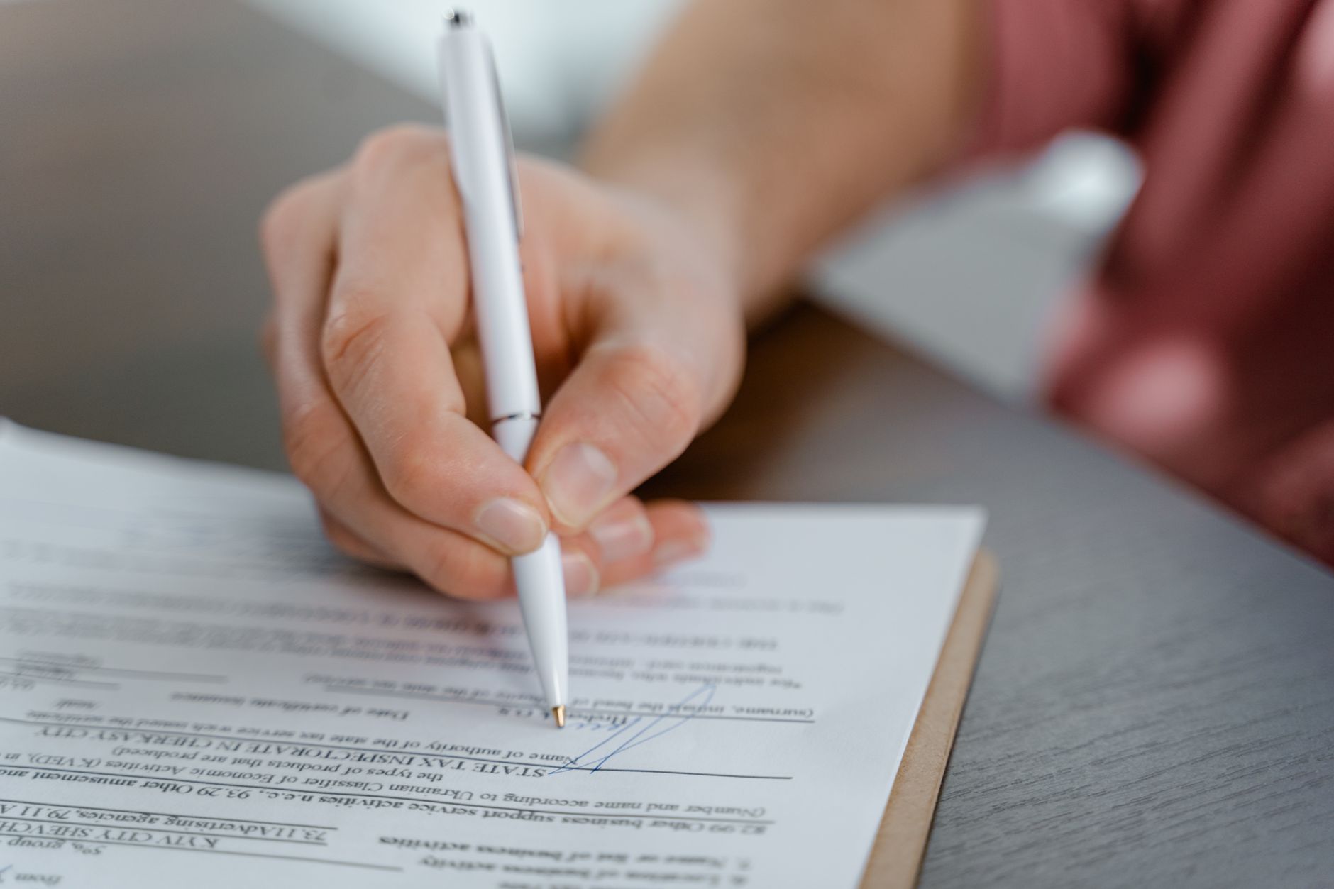 Two business professionals reviewing and signing a leasing contract at a desk