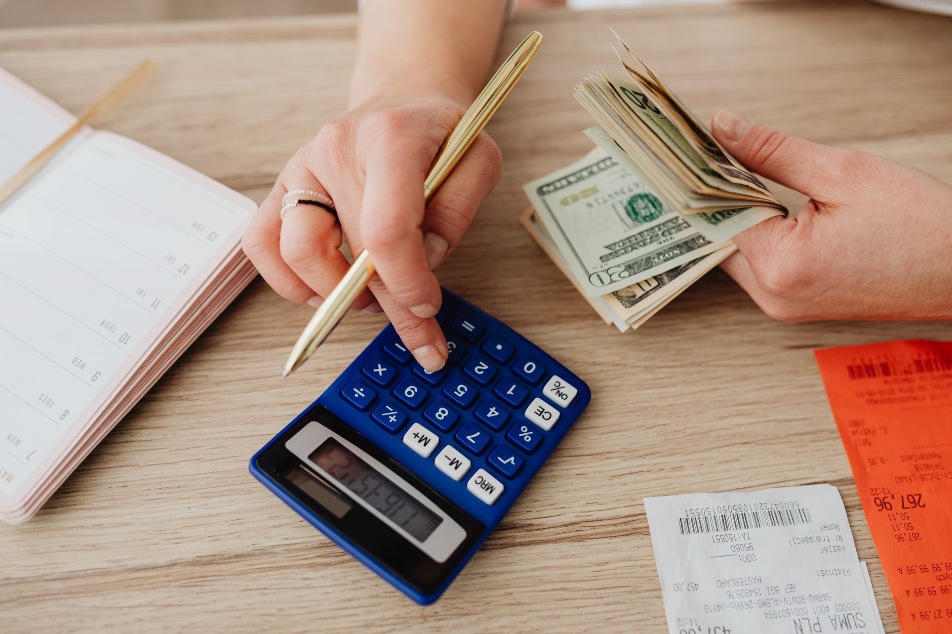 Retiree using calculator to plan fixed income cash flow schedule