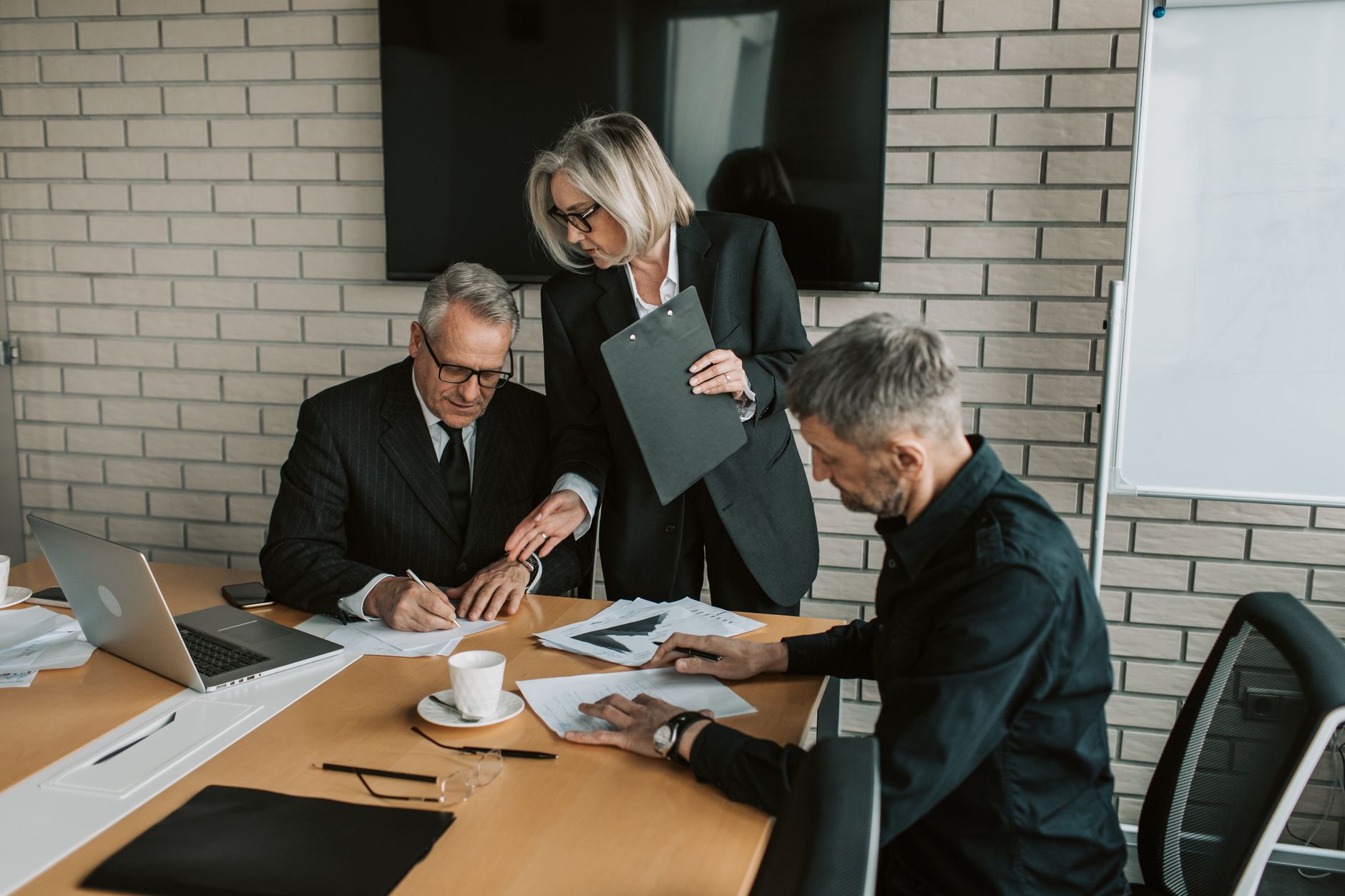Corporate executives in a boardroom discussing long-term compliance and procurement strategy